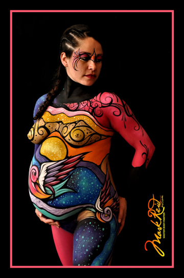 dark haired woman who is pregnant who is standing with her hand cradeling her belly in full body paint