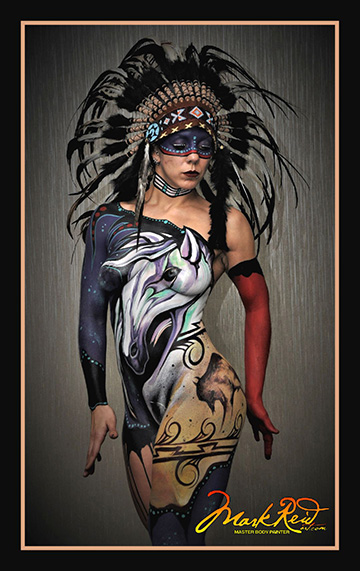 Woman body painted with a native American theme in blue hues looking down and to the right