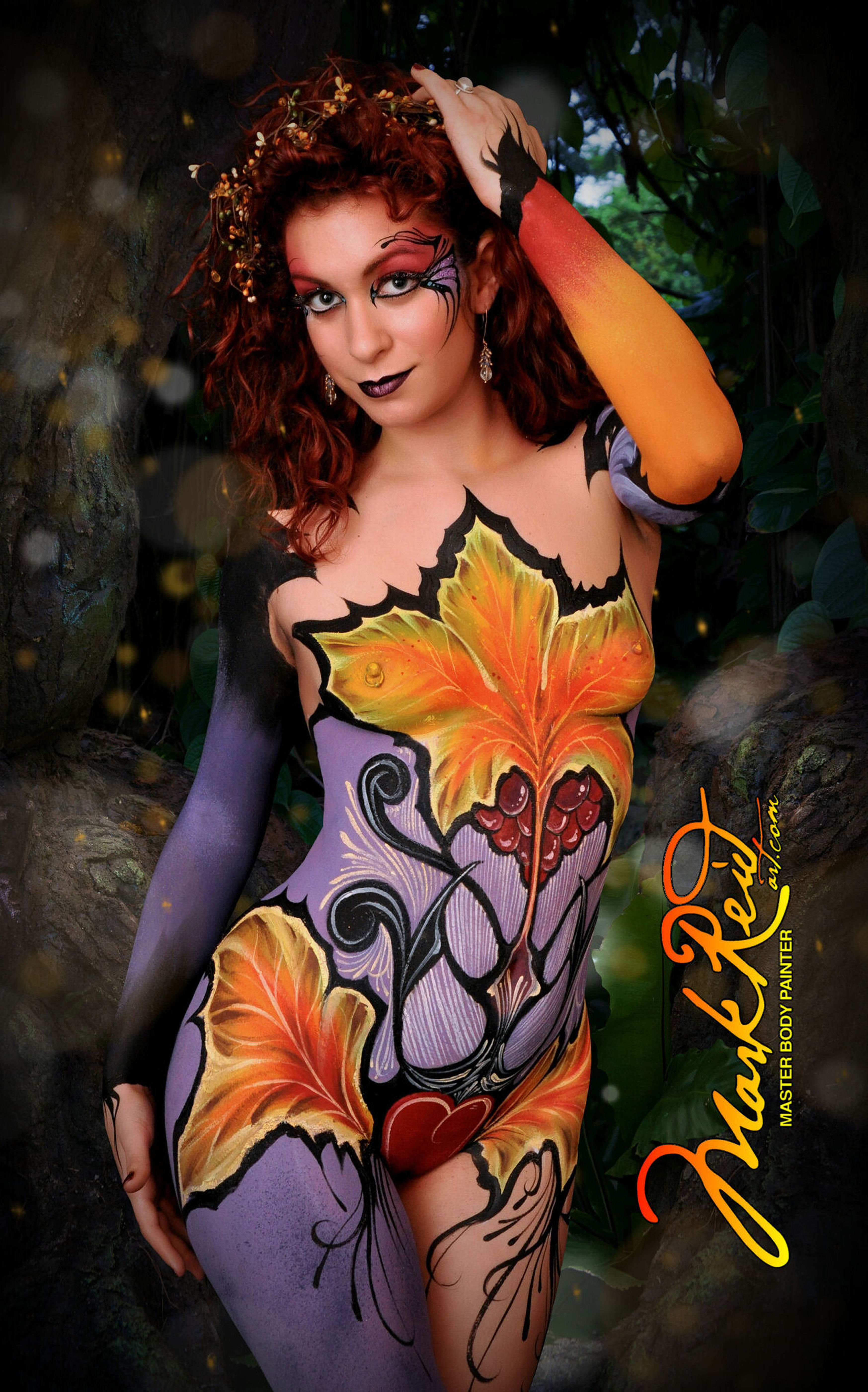 Red/brunette haired beauty sporting a full body painting that has elements of grape vines.  Very detailed painting.