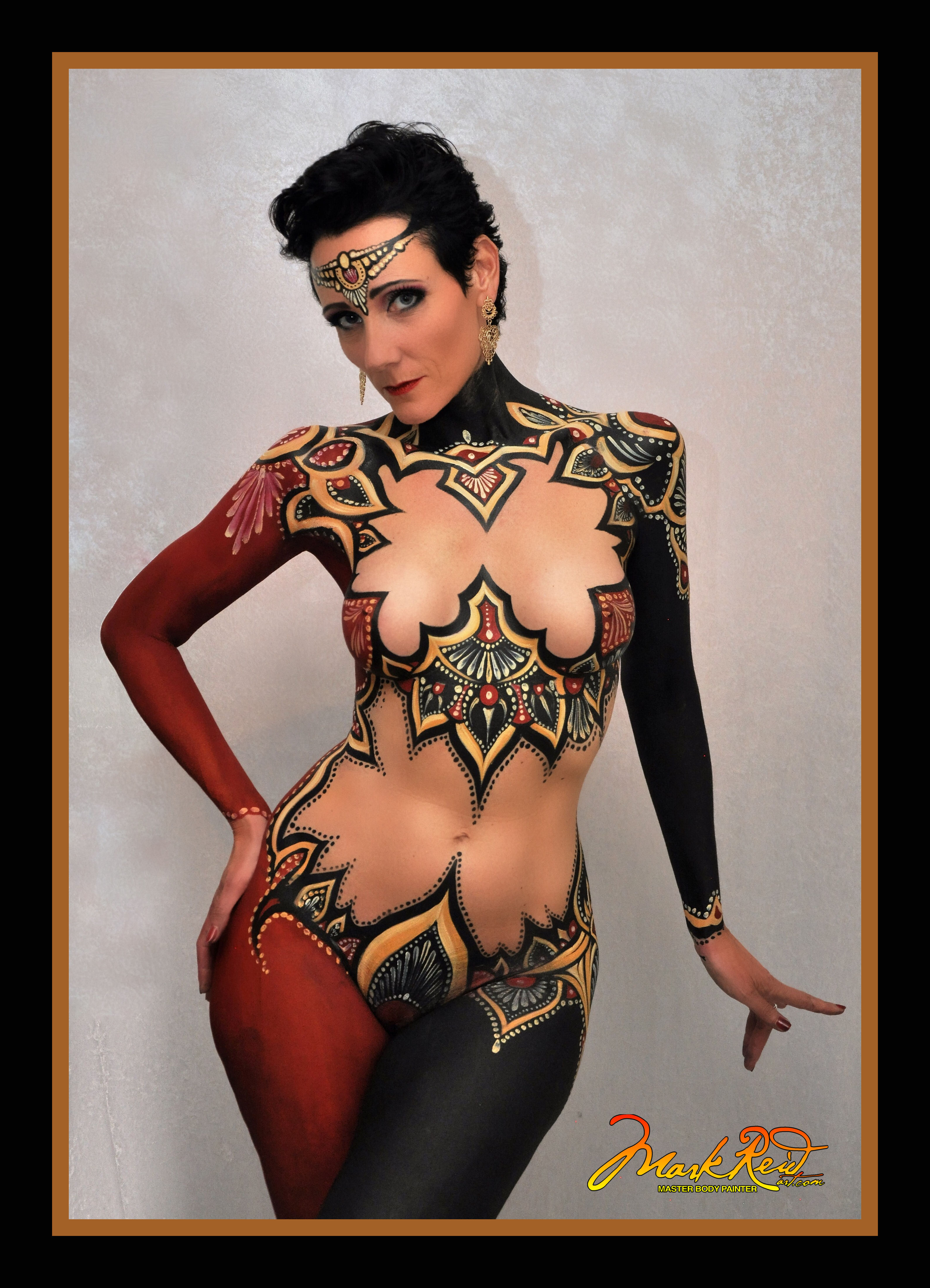 Beautiful short black haired woman with an extremely detailed full body painting in red black and gold