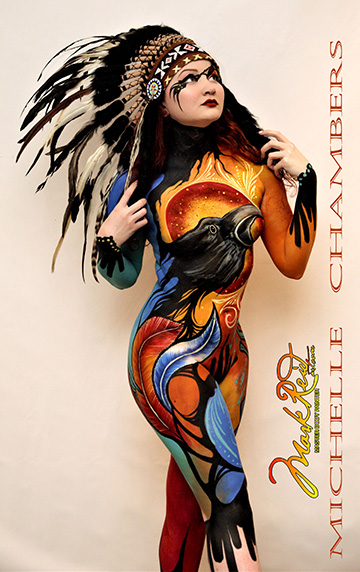 Model in southwestern US themed colorful full body paint with a full head dress